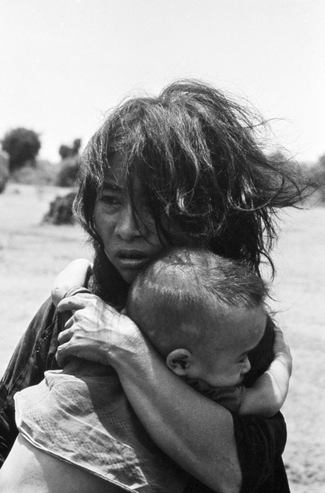 Khuôn mặt thất thần của người mẹ và em bé khoảng 6 tháng tuổi khi nghe tiếng súng nổ từ nơi tạm cư. Ảnh: Jean-Claude Sauer.