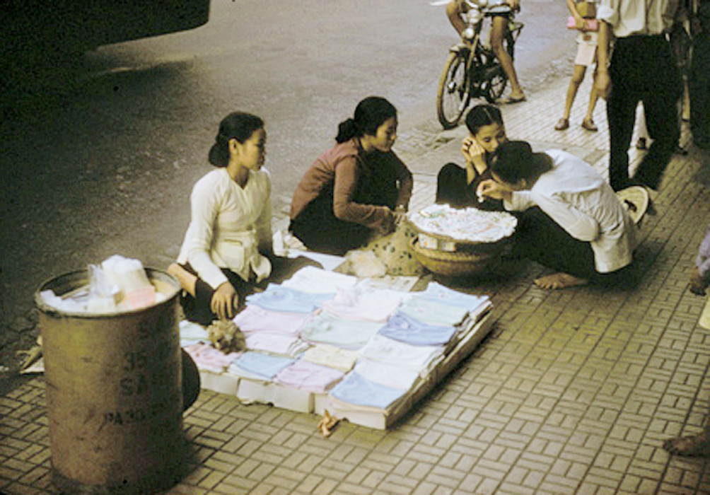 Các phụ nữ trẻ tán gẫu bên quầy hàng rong vỉa hè. Ảnh: Richard C. Harris.