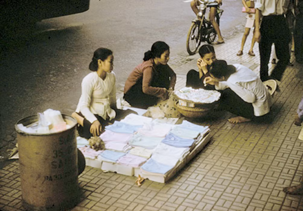 Các phụ nữ trẻ tán gẫu bên quầy hàng rong vỉa hè. Ảnh: Richard C. Harris.