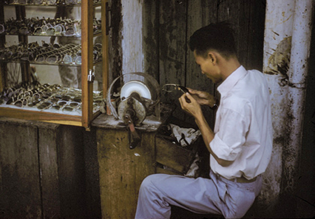 Sạp hàng đơn sơ của người thợ làm kính mắt vỉa hè. Ảnh: Richard C. Harris.