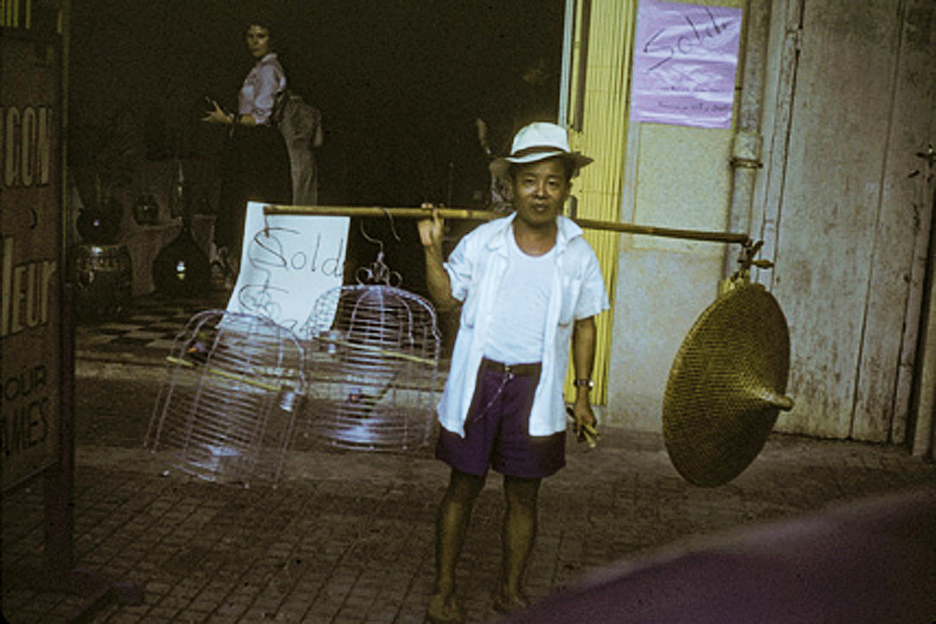 Người đàn ông bán lồng chim bằng nhôm ở Chợ Lớn. Ảnh: Richard C. Harris.
