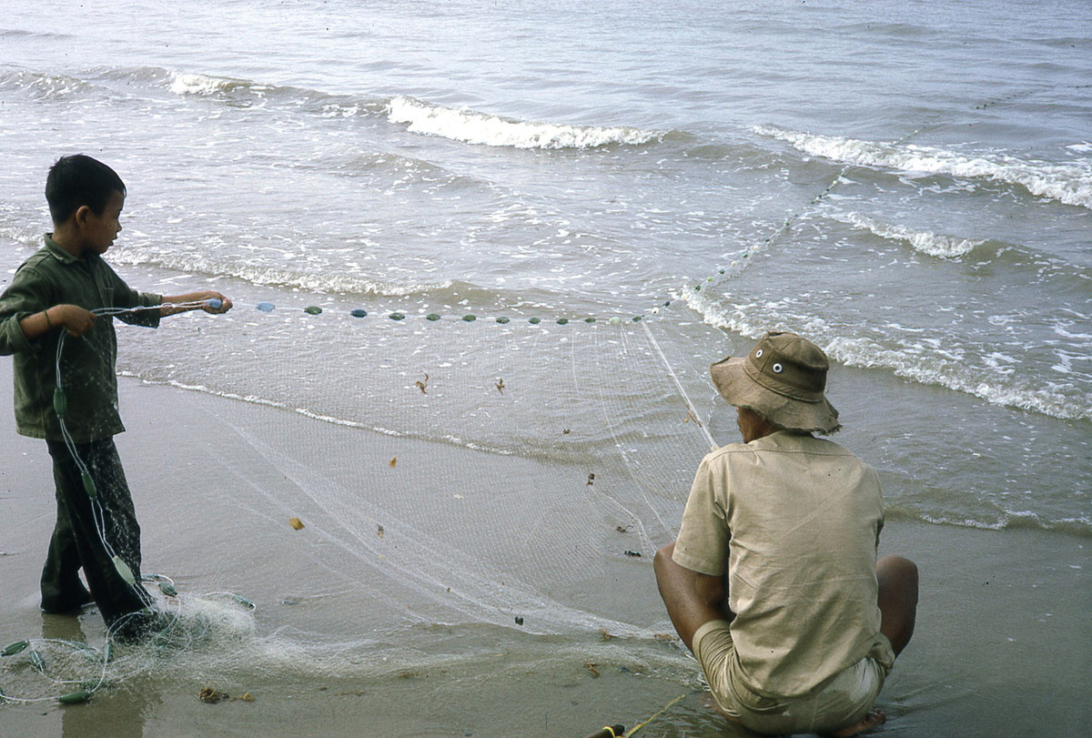 Người ngư dân và con trai kéo lưới. Ảnh: Donald MacKinnon.