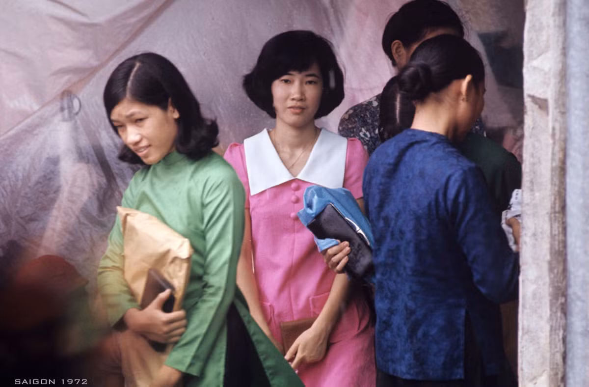 Sắc màu rực rỡ từ trang phục đa dạng của những người phụ nữ bên ngoài một quầy hàng trên đường phố Sài Gòn năm 1972. Ảnh: Patrice Habans.