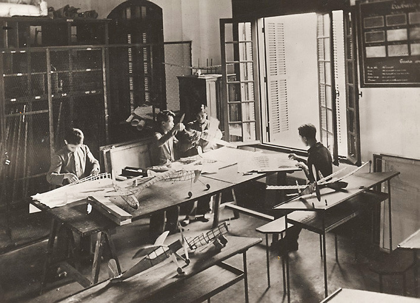 Học sinh làm mô hình máy bay trong lớp kỹ nghệ thực hành tại một ngôi trường ở Huế, 1931. Ảnh tư liệu.