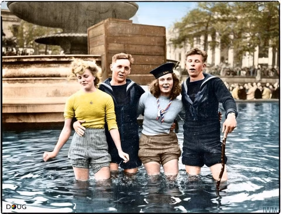Hai thủy thủ Anh mừng ngày chiến thắng với bạn gái tại đài phun nước Quảng trường Trafalgar, London ngày 8/5/1945. Ảnh: Vintag.