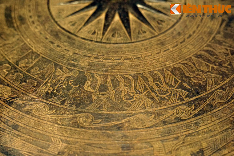 Nhóm thứ nhất trang trí hình 6 người hóa trang lông chim nhảy múa theo chiều trái sang phải. Trong đó một người cầm rìu chiến, một người thổi khèn, bốn người đội mũ lông chim, tay cầm giáo.