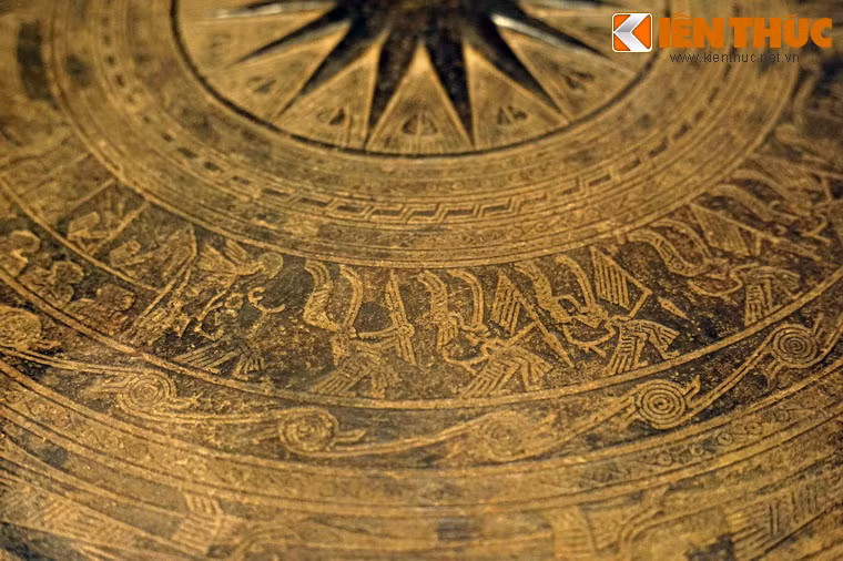 Nhóm thứ nhất trang trí hình 6 người hóa trang lông chim nhảy múa theo chiều trái sang phải. Trong đó một người cầm rìu chiến, một người thổi khèn, bốn người đội mũ lông chim, tay cầm giáo.