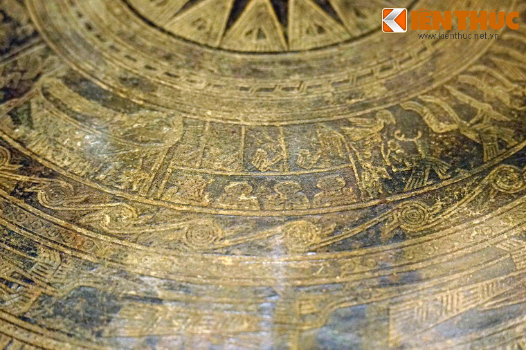 Nhóm thứ 5 là cảnh đánh trống đồng, có bốn người ngồi trên dàn trống gồm bốn chiếc, tay cầm gậy dài.