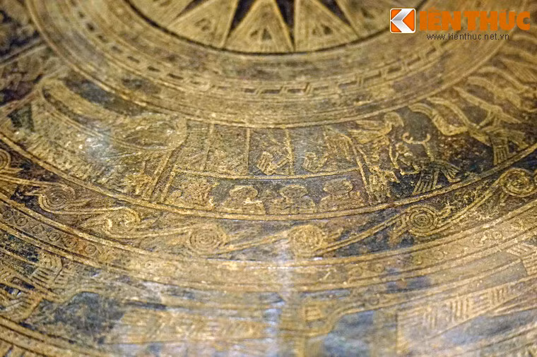 Nhóm thứ 5 là cảnh đánh trống đồng, có bốn người ngồi trên dàn trống gồm bốn chiếc, tay cầm gậy dài.