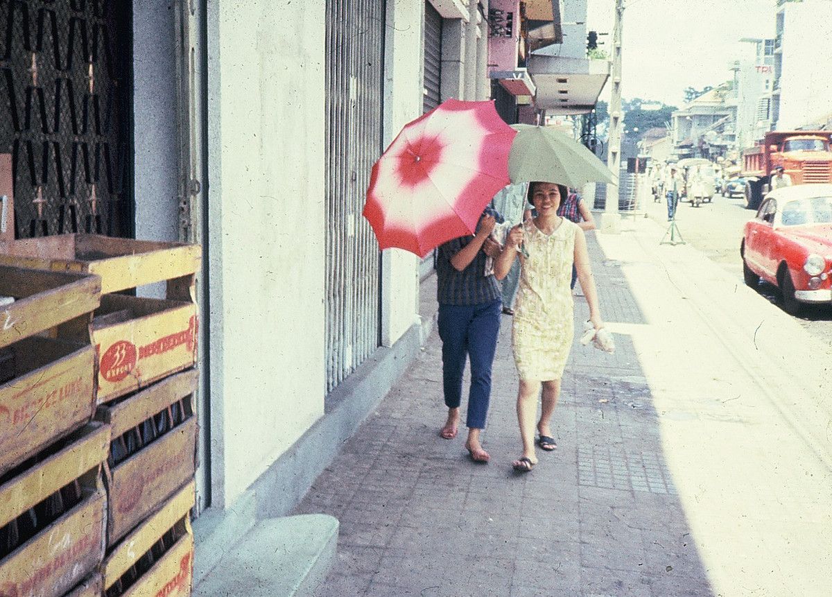 Hai cô gái che ô trên vỉa hè đường Hai Bà Trưng. Ảnh: Dale Ellingson.