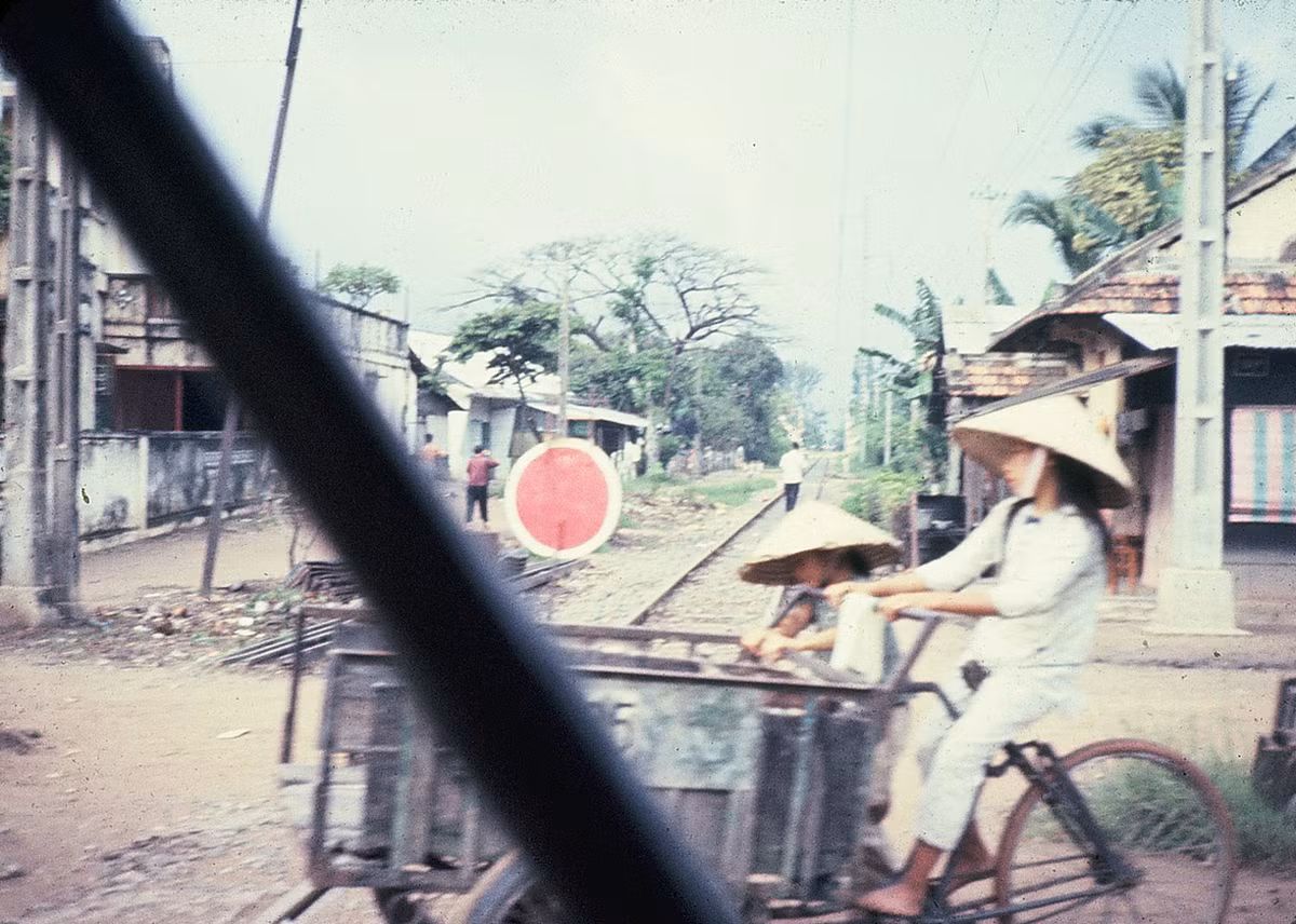Thiếu nữ đạp xe ba gác băng qua đường tàu. Ảnh: Dale Ellingson.