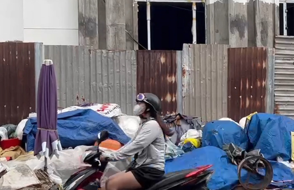 Hiện tại, xung quanh dự án được quây lại bởi các tấm tôn, bên trong thì ngổn ngang vật liệu xây dựng. Bên ngoài trở thành nơi tập kết rác, ô nhiễm, nhếch nhác. (Ảnh: SGGP).