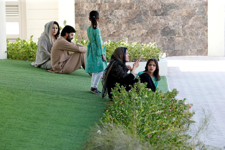 Người dân sơ tán từ Afghanistan ngồi trong một công viên tại khu nhà ở tạm thời ở Doha, Qatar, ngày 27/8.