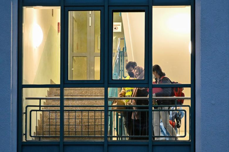 Những bức ảnh của hãng Reuters phần nào cho thấy cuộc sống của người dân Afghanistan sau khi được sơ tán tới các quốc gia khác. Ảnh: Một người phụ nữ sơ tán khỏi Kabul nhận được sự giúp đỡ từ các thành viên của Hội Chữ thập Đỏ Đức tại khu trại ở Doberlug-Kirchhain, Đức, ngày 20/8.