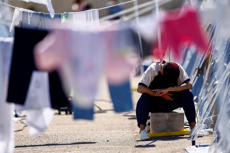 Người đàn ông ngồi trong trung tâm tiếp nhận tạm thời do Hội Chữ thập Đỏ Italy quản lý tại Avezzano, Italy, ngày 30/8 trong thời gian cách ly.