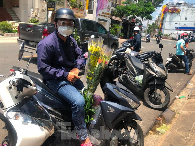 Người dân tranh thủ mua đồ cúng trong rằm tháng Bảy. "Dù các điểm bán trái cây, hoa cúng đều đông người, mình lo lắng khi ra ngoài nhưng cũng tranh thủ mua nhanh vì không thể đặt các mặt hàng này online" - anh Tú nói.