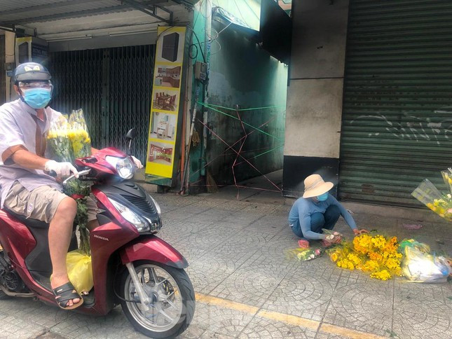 Một số người tranh thủ đem hoa xuống vỉa hè bán dịp rằm, kiếm được đồng nào đỡ đồng nấy trong những ngày dịch.