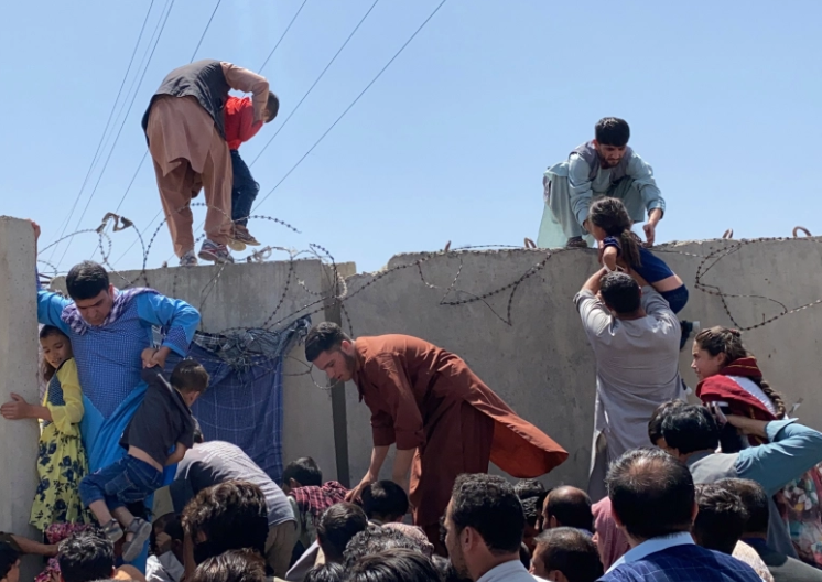 Nhiều người trèo tường để vào sân bay Hamid Karzai.