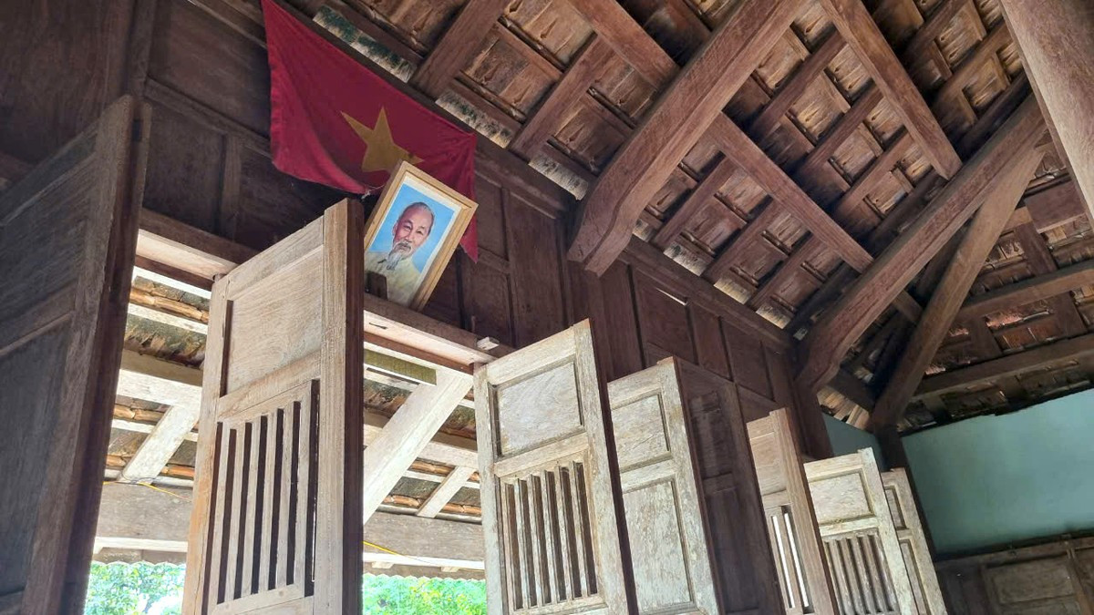 Chính giữa ngôi nhà treo cờ Tổ quốc và ảnh Bác Hồ.
