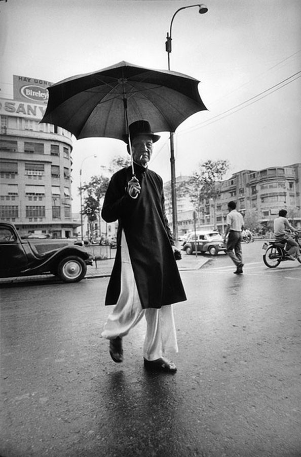 Cụ ông che ô trên đại lộ Nguyễn Huệ, gần thương xá Passage Eden.