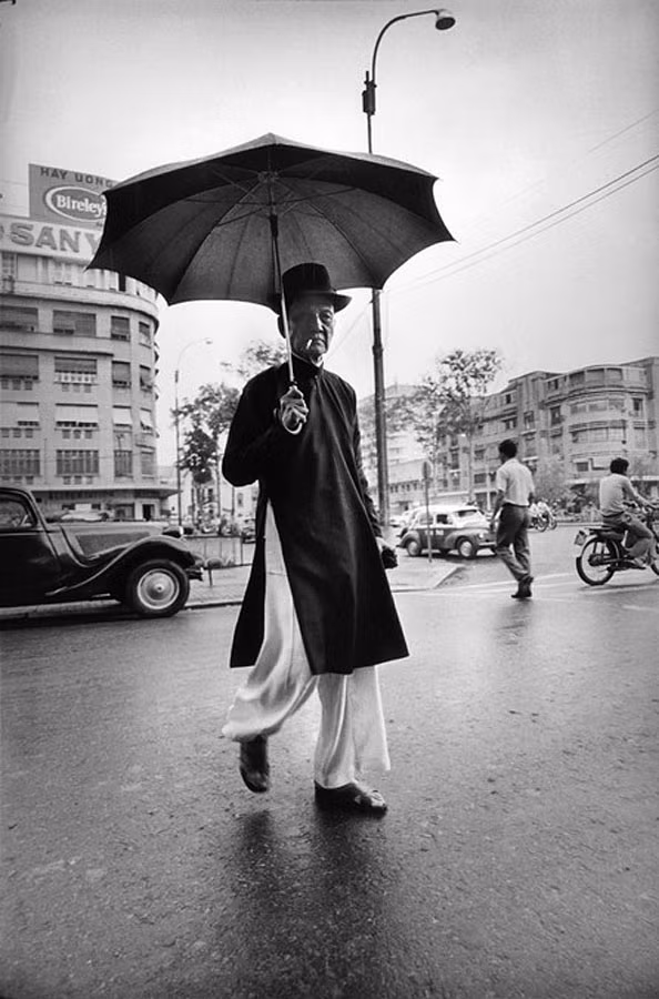 Cụ ông che ô trên đại lộ Nguyễn Huệ, gần thương xá Passage Eden.