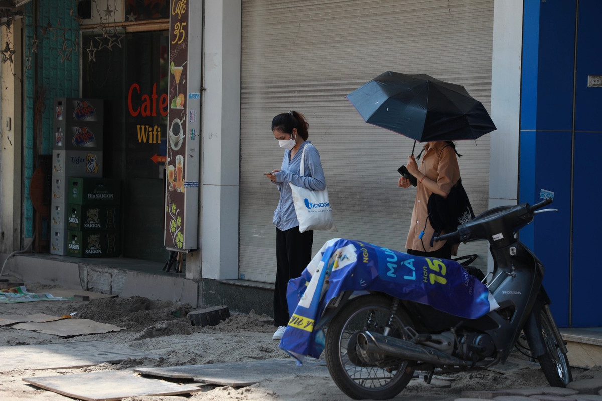 Nhiều người phải tận dụng bóng râm ít ỏi của những ngôi nhà trên tuyến đường Kim Đồng để dừng chân.