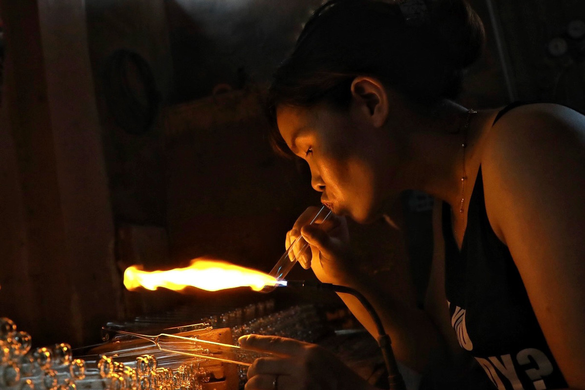 Miệng thổi thủy tinh, tay thì xoay, vuốt để tạo hình sản phẩm theo ý muốn.