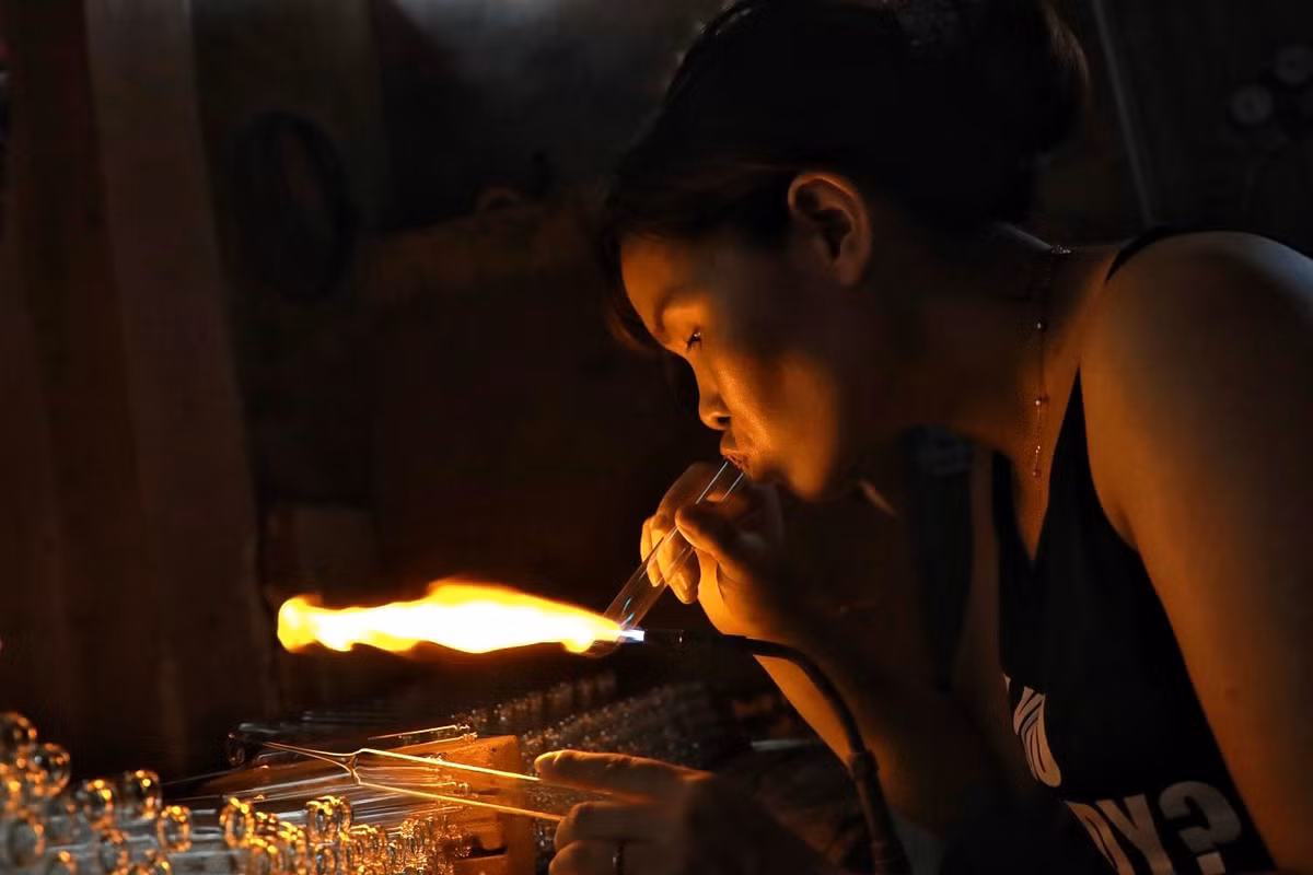 Miệng thổi thủy tinh, tay thì xoay, vuốt để tạo hình sản phẩm theo ý muốn.