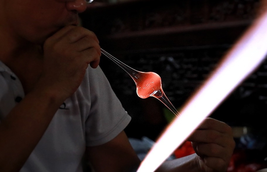  Để làm ra sản phẩm thuỷ tinh, đầu tiên người thợ phải nung nóng ống tuýp thủy tinh để kéo ra từng khúc ngắn. Sau đó thợ thổi khí vào những túyp thủy tinh đã được hơ nóng, làm phồng lên và tạo hình theo ý muốn.