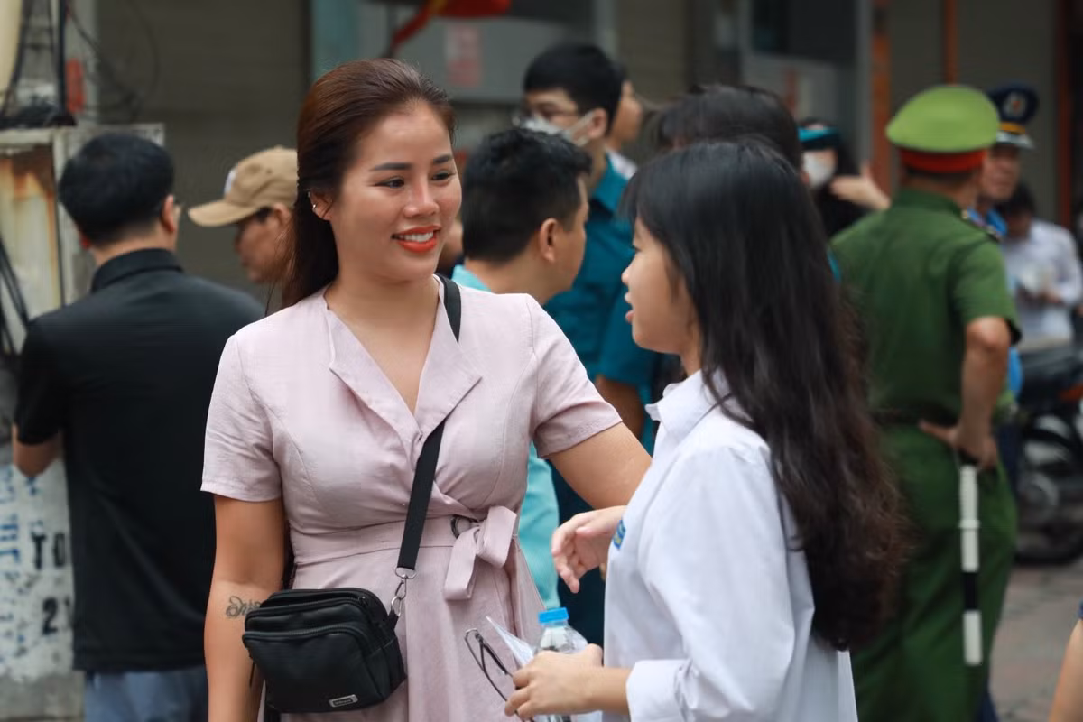 Nở nụ cười tươi kèm lời chúc con thi thật tốt.