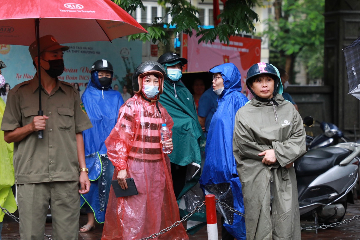 Trước đó, mặc dù trời mưa to nhưng phụ huynh vẫn lo lắng, ngóng chờ. các thí sinh phía ngoài cổng trường.