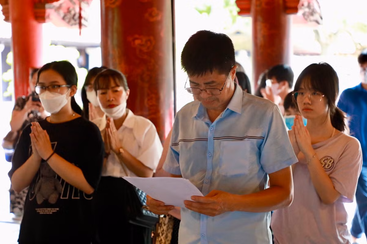 Từng tốp phụ huynh, học sinh thành kính dâng hương, cầu may mắn.