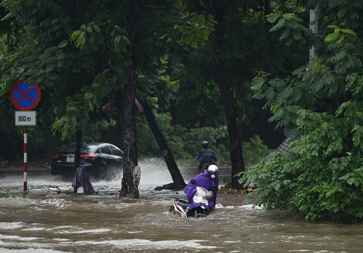 Không ít xe máy không kịp tránh đã bị sóng đánh đổ giữa đường.