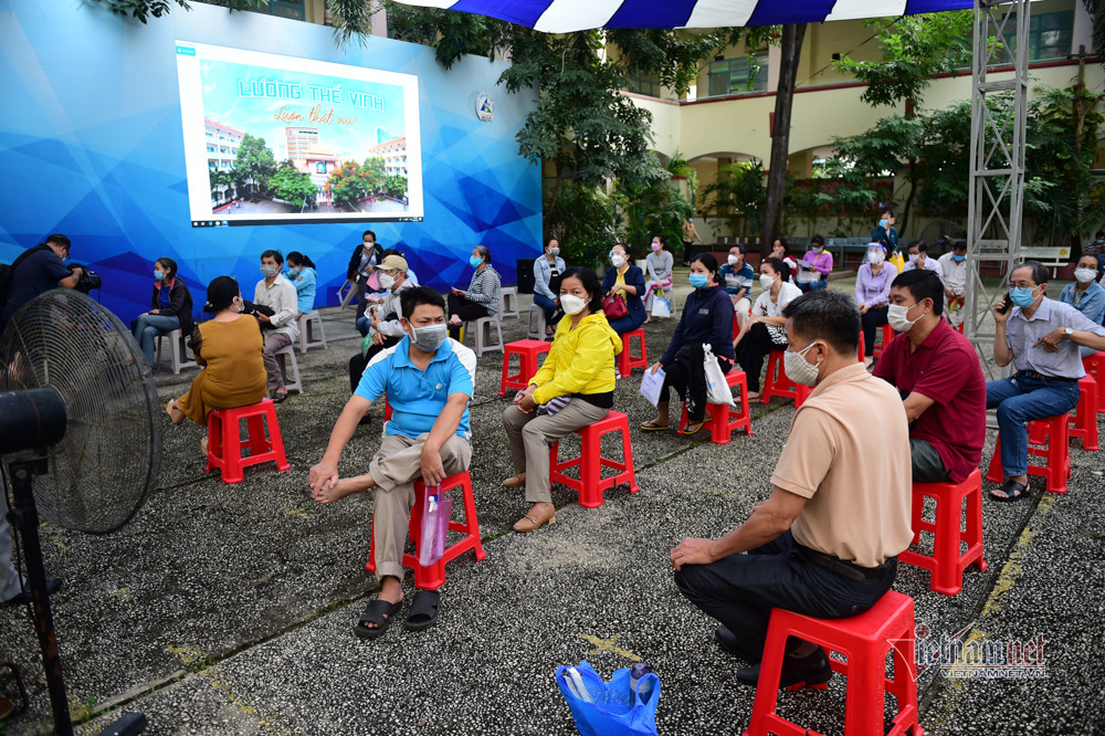 Phụ huynh ngồi đợi bên ngoài chờ các em tiêm xong