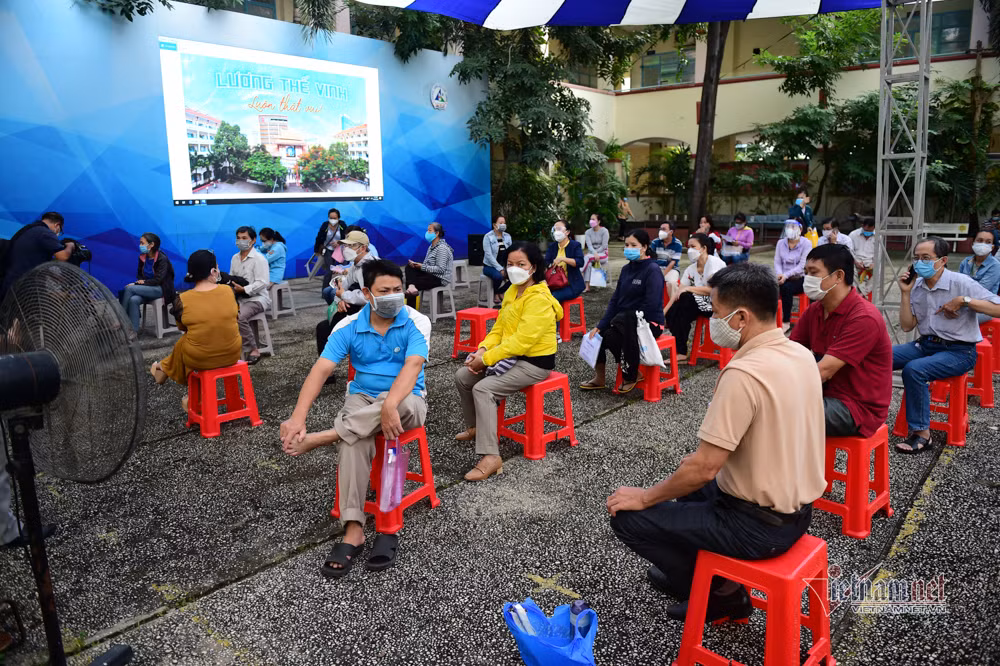 Phụ huynh ngồi đợi bên ngoài chờ các em tiêm xong