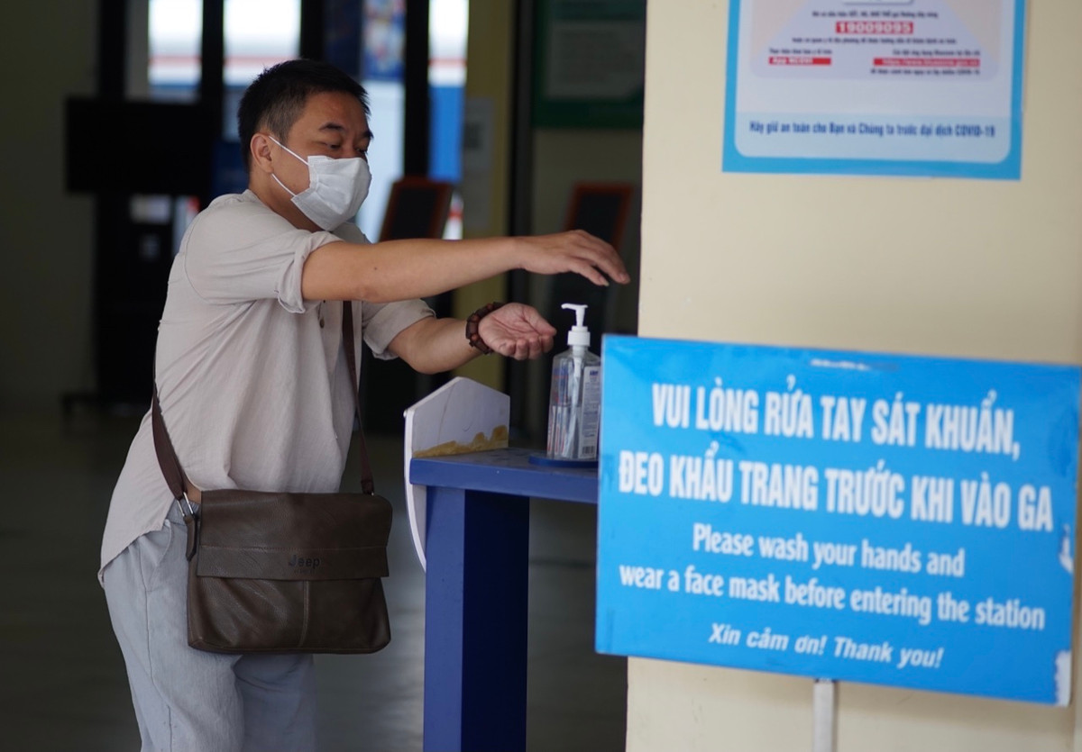 Theo ghi nhận của PV báo Tri thức và Cuộc sống, khách đến mua vé phải được kiểm tra thân nhiệt và yêu cầu khử khuẩn trước khi vào Ga Hà Nội thực hiện giao dịch.
