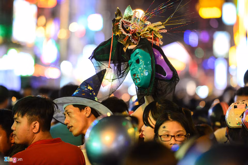 Người đàn ông cố thoát khỏi đám đông trên đường Bùi Viện để bán những chiếc mặt nạ hóa trang giá từ 50.000 đồng đến 200.000 đồng.