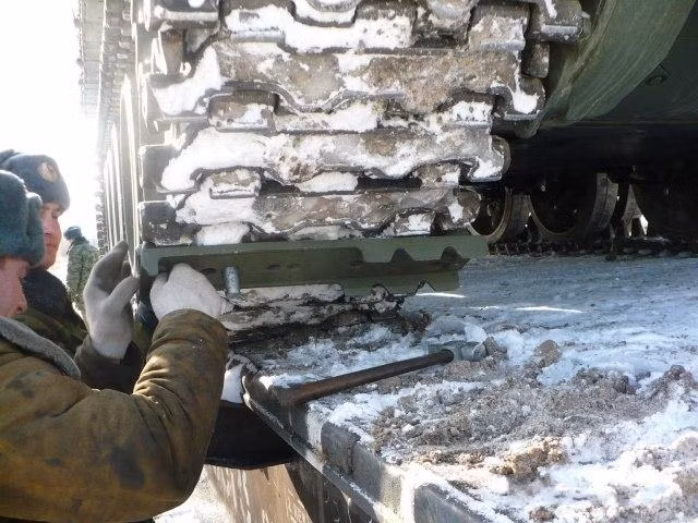 Các binh sĩ đang cố định xích xe tăng T-62 vào khoang hàng tàu hỏa.