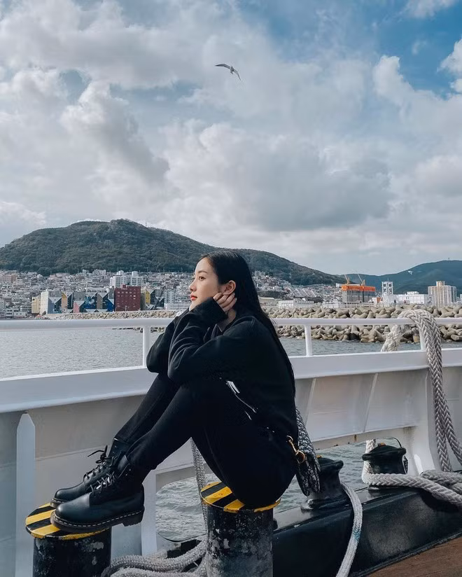 Thoát style quyến rũ, Jun Vũ cũng không ngại diện nguyên cây đen khi ghé thăm Busan, Hàn Quốc. Cô chọn cho mình chiếc áo nỉ oversized phối cùng quần legging và giày da cổ cao đồng màu. Điểm nhấn cho cả set đồ là chiếc túi đến từ thương hiệu Dior Saddle có giá khoảng 3.000 USD.