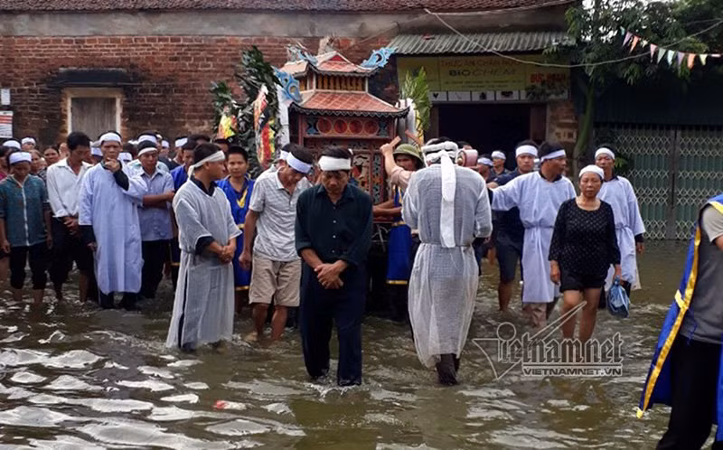 Anh Nguyễn Tự Ba, con rể cụ Hoàng Công Đào cho biết: “Ngày cụ mất, lúc tổ chức tang lễ rất khó khăn, anh em dư tráng cùng người thân, họ hàng, làng xóm đưa cụ trên chiếc thuyền rồng, mò mẫm trong dòng nước dịch chuyển từng bước đưa cụ lên chỗ cao nhất trong xã. Từ đó mới chuyển di hài lên ô tô đưa về nghĩa trang Vĩnh Hằng hoả táng”. Ảnh: Những ngày này, nước cô lập cả xã Nam Phương Tiến.