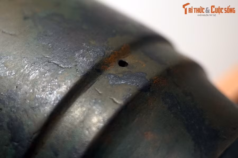 Phía dưới hai hàng chữ Hán, ở phần tiếp giáp giữa phần bầu và chuôi súng có một lỗ tròn, đường kính 0,45 cm, đây có thể là lỗ điểm hỏa.