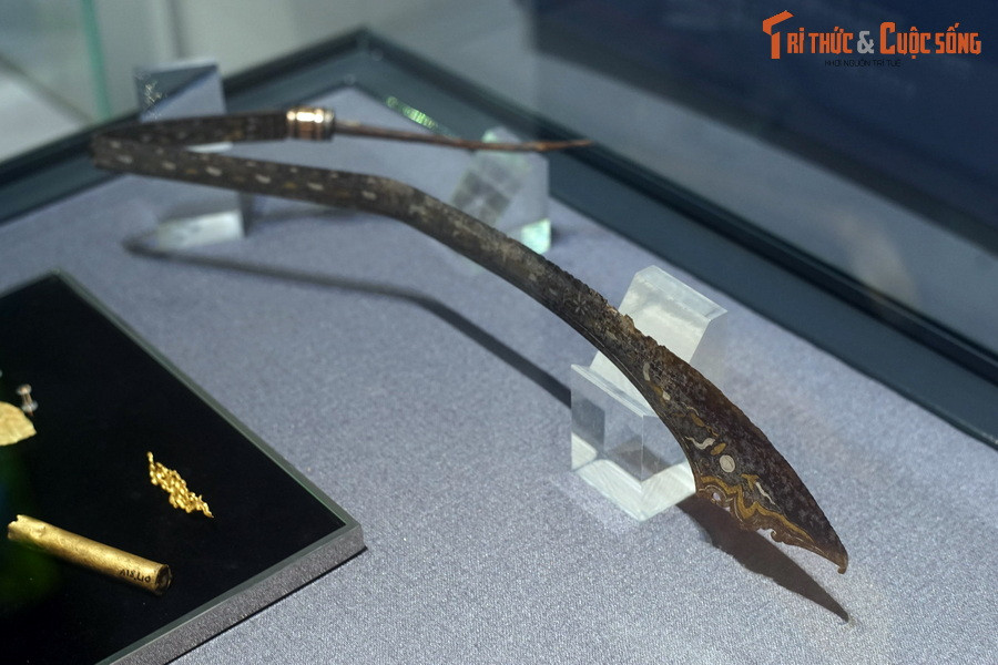 Hiện vật này có từ thế kỷ 13-14, cấu tạo gồm hai phần thân và cán. Trong đó thân đao dài 64 cm. Phần thân tại vị trí tiếp giáp với cán rộng 1,4 cm, sống dày 1,0 cm và rộng dần về mũi, phần rộng nhất của mũi rộng 5,1 cm, dày 0,1 cm.