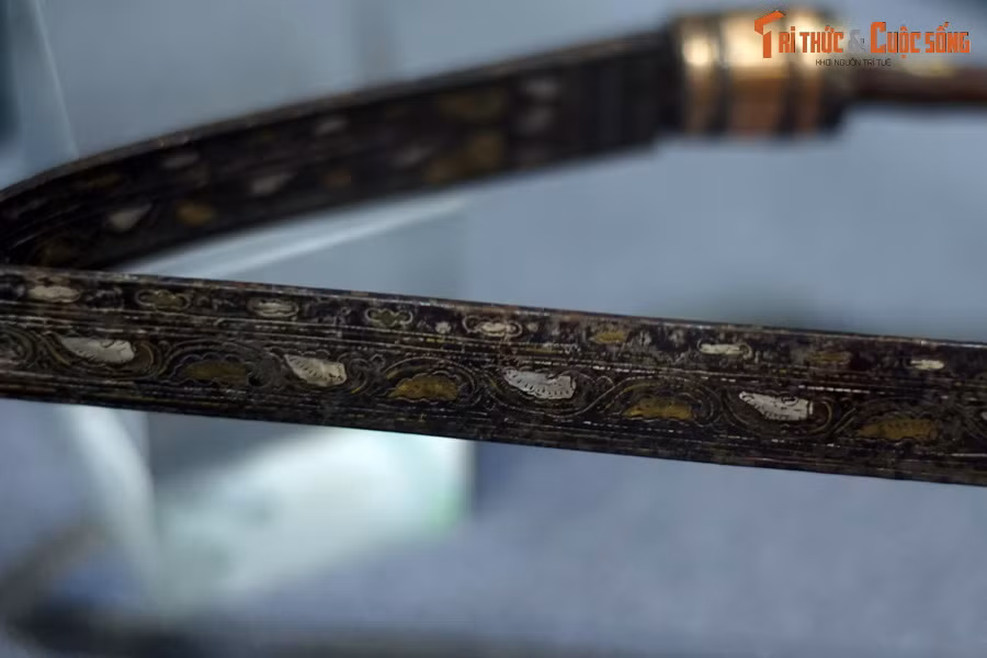 Phần thứ hai trang trí đồ án dây lá, lá lật hình sin theo quy luật lá màu trắng ứng với lá vàng. Bao quanh dải dây lá là các đường chỉ mảnh nhưng rõ ràng.