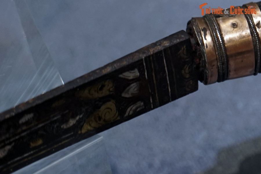 Đồ án hoa văn có thể được chia làm ba phần. Phần thứ nhất, tiếp giáp giữa thân và cán là bố cục hai lớp cánh sen, giữa hai lớp là các đường chỉ chìm và chấm tròn, tạo cảm giác làm nền cho đồ án hoa văn tiếp theo.