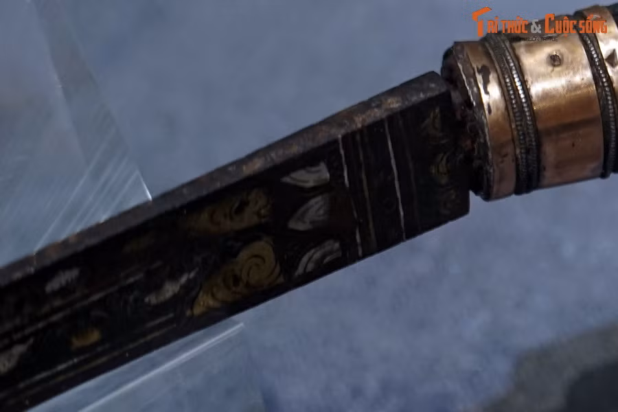 Đồ án hoa văn có thể được chia làm ba phần. Phần thứ nhất, tiếp giáp giữa thân và cán là bố cục hai lớp cánh sen, giữa hai lớp là các đường chỉ chìm và chấm tròn, tạo cảm giác làm nền cho đồ án hoa văn tiếp theo.