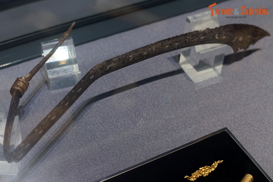 Sống đao được trang trí hoa văn dây lá với họa tiết lá xoắn hình sin chạy từ cán đến mũi những chấm nhỏ liên tiếp khắc chìm.