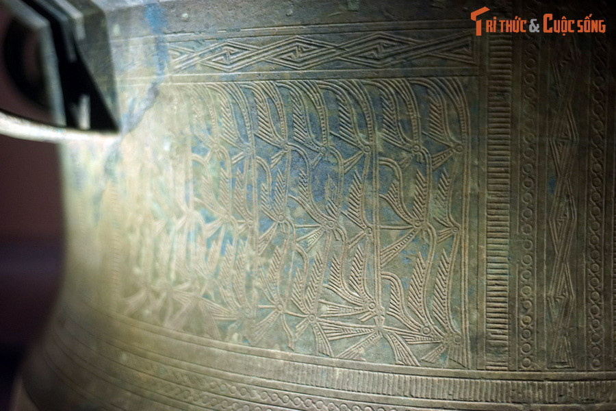 Thân trống trang trí hình người hóa trang lông chim.