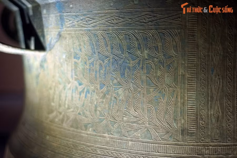 Thân trống trang trí hình người hóa trang lông chim.