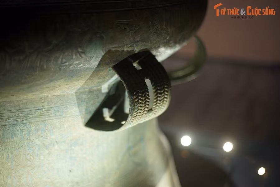 Giữa thân trống và tang trống có hai đôi quai kép trang trí nổi hoa văn hình bông lúa.