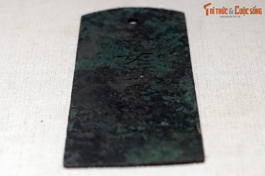 Được phát hiện và bảo quản, trưng bày tại Di sản thế giới Hoàng thành Thăng Long, hiện vật này là tấm hợp kim đồng, phẳng, mỏng, hình thang cân, hai góc của cạnh trên của hình thang được tỉa cong.